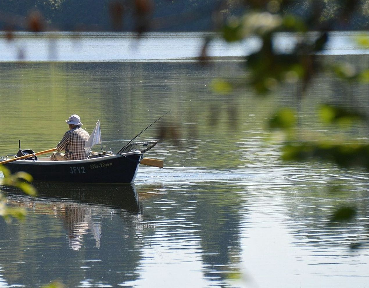 Una cabaña en el bosque con mapas de lagos, equipo de pesca y cuadernos abiertos